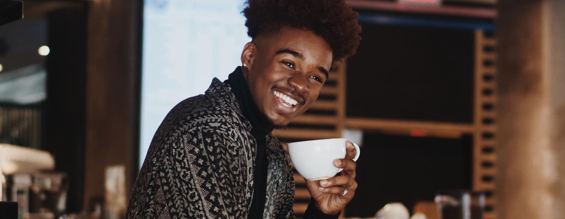 lifestyle image of a young man at a coffee shop
